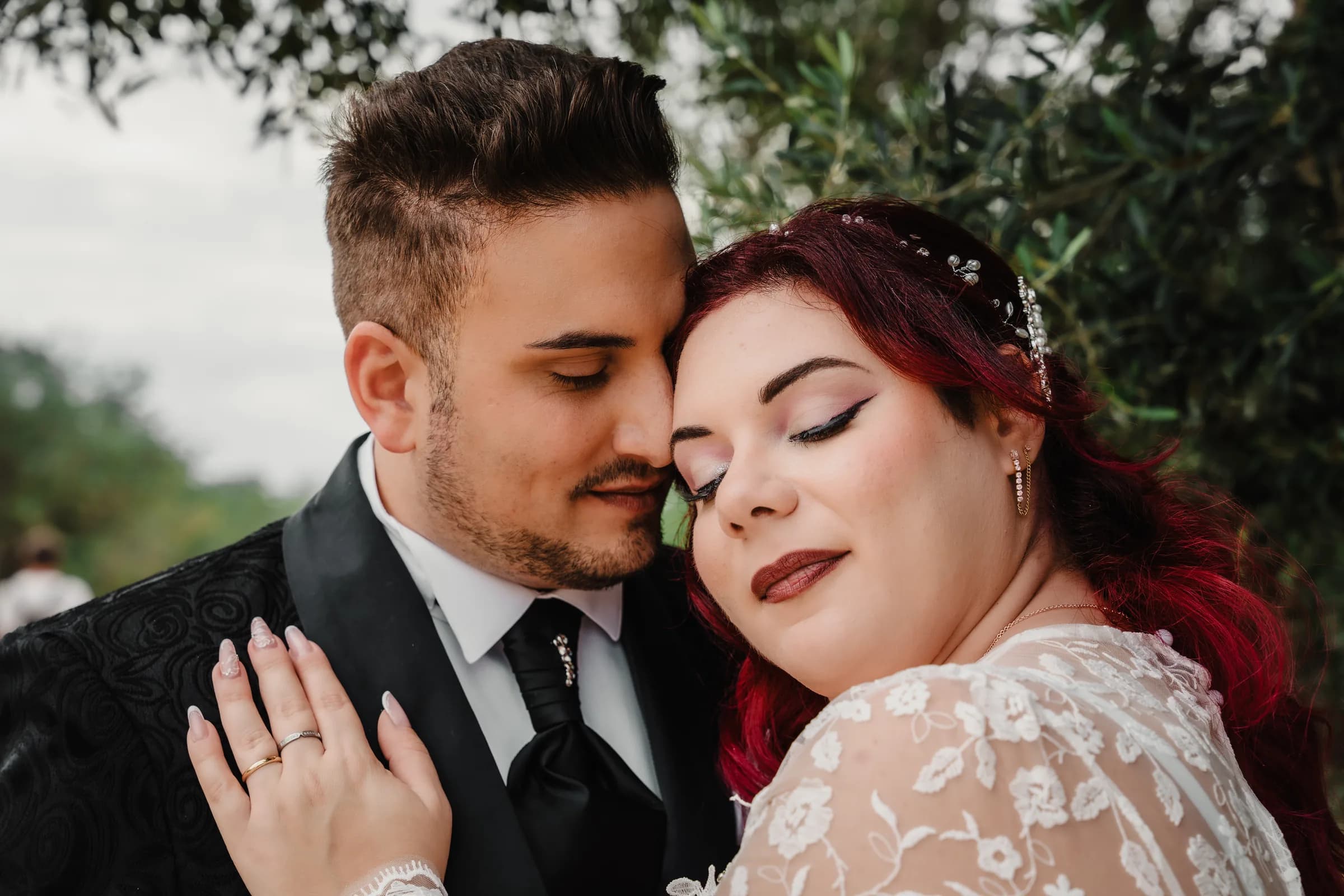 A couple pressed cheek to cheek with their eyes closed